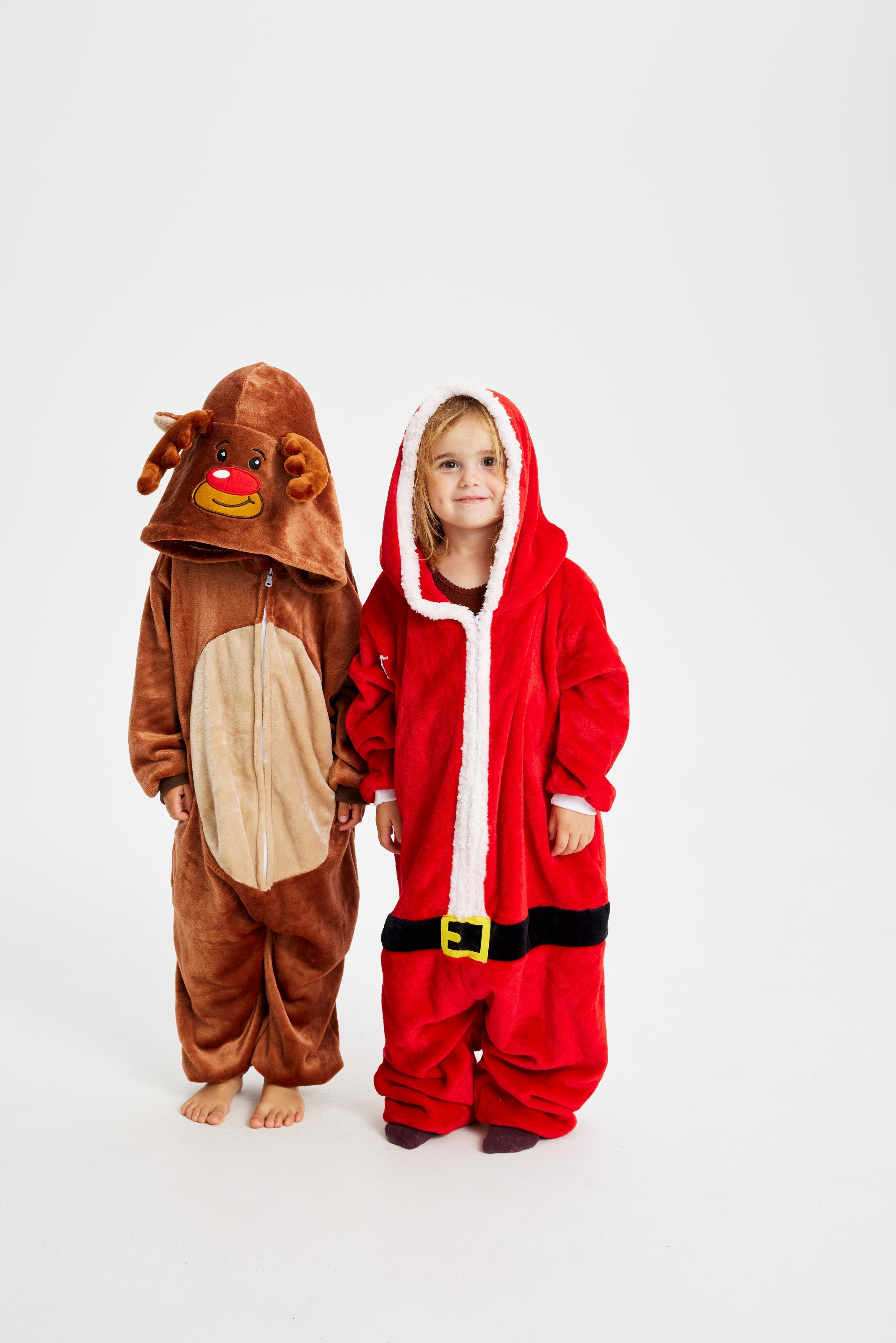 Deux enfants posent ensemble en portant leur costume de Noël.